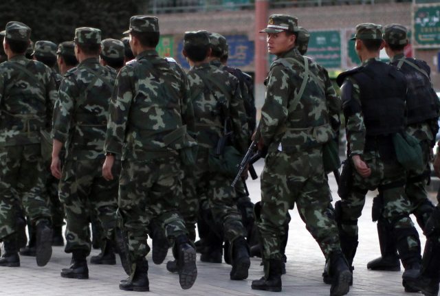 Armed police officers patrol an ethnice Uighur area in Kashgar, in Xinjiang province