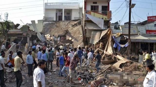 REFILE - ADDING ADVISORYATTENTION EDITORS - VISUAL COVERAGE OF SCENES OF INJURY OR DEATHPeople stand near the site of an explosion in Jhabua district at Madhya Pradesh, India, September 12, 2015. At least 60 people were killed in the town in central India on Saturday when a cooking gas cylinder blew up in a restaurant and set fire to explosives stored nearby, police said. REUTERS/Stringer  TEMPLATE OUT