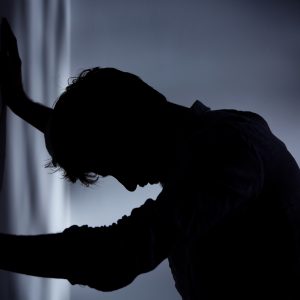 Man leaning hands against wall