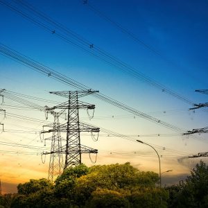 Sun setting behind the silhouette of electricity pylons